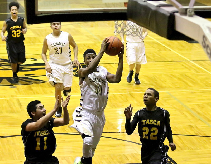 Image: Eric Carson(11) glides to the glass between two Itasca defenders.