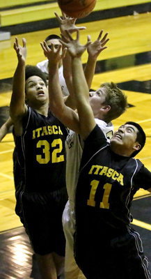 Image: James Walton(13) challenges a pair of Itasca players for the rebound.