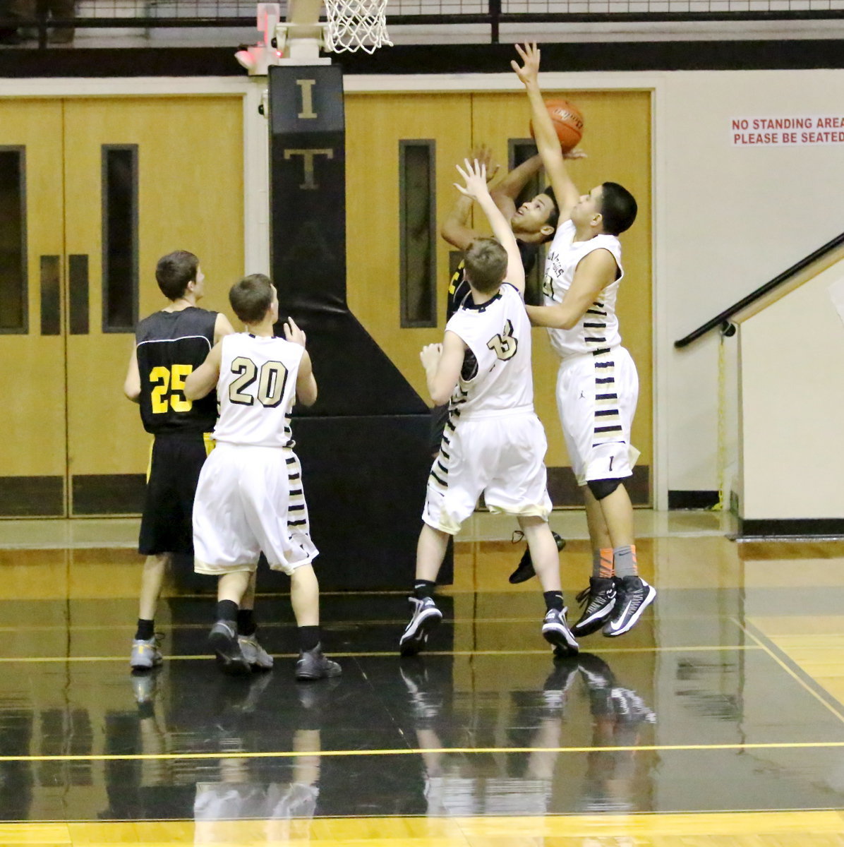 Image: James Walton(13) and David De La Hoya(21) try to keep an Itasca shooter from scoring under the basket while teammate Joshua Cryer(20) takes away the passing lane.