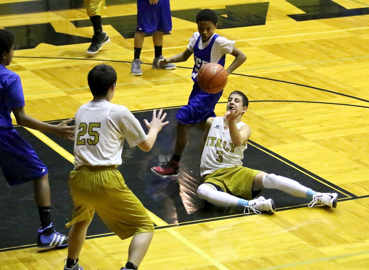 Image: 8th grader, Gary Escamilla(3) passes to teammate Kyle Tindol(25) from a seated position.