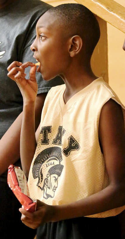 Image: John Hall, Jr. enjoys a bag of chips from the concession stand while checking out his fellow IYAA players in action.