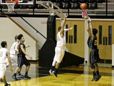 Image: Tristan Cotten(33) leaps out to pressure a JV Wampus Cat shooter.