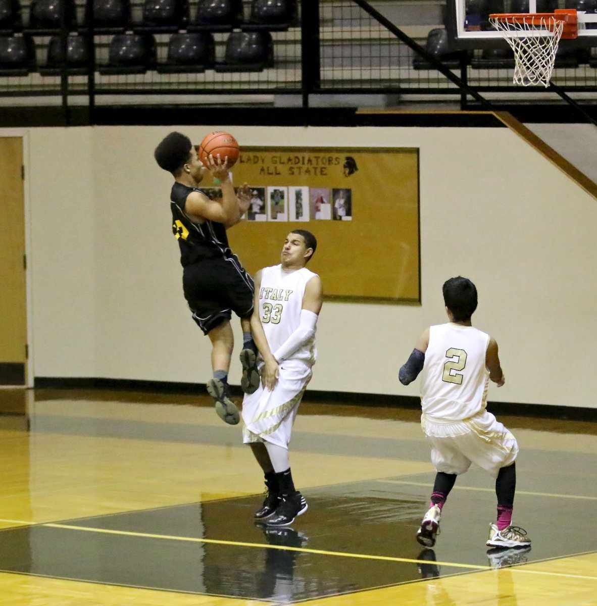 Image: Italy’s Tristan Cotten(33) uses textbook form to draw a charging foul against Itasca.