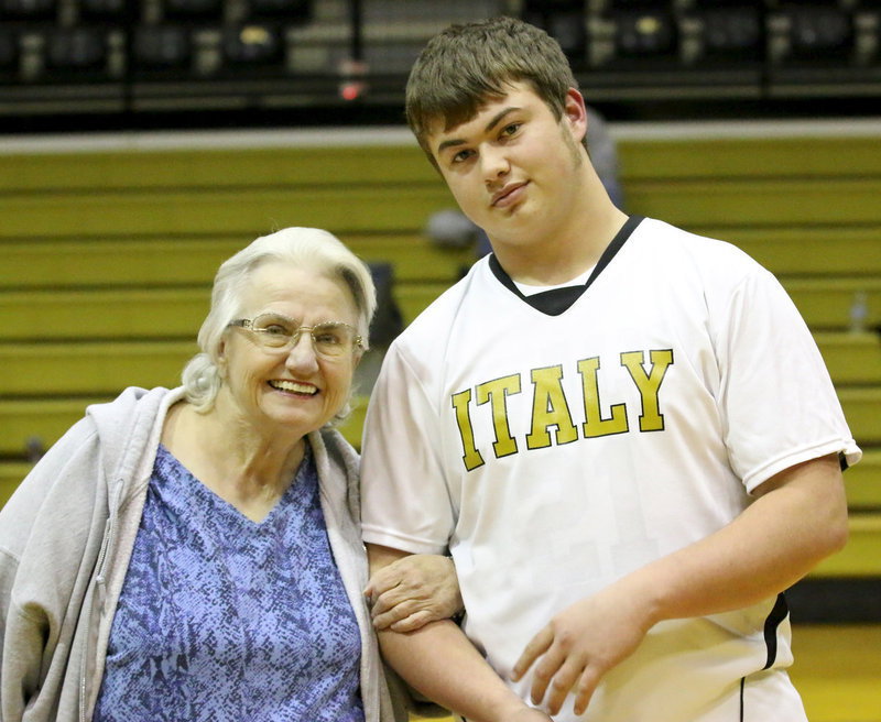Image: Zain Byers is escorted by his grandmother, Ann Byers, during the pre-game ceremony honoring Italy’s basketball seniors as they prepare to play their final home game wearing the gold and white.