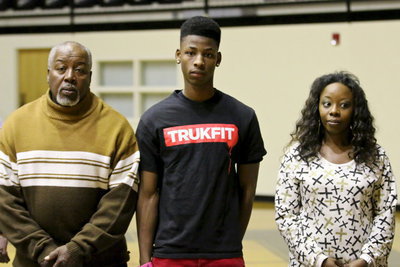 Image: Gladiator senior, Eric Carson is honored during the pre-game ceremonies while being escorted by his grandfather, Ervin Green and, his mother, Timeka Green.