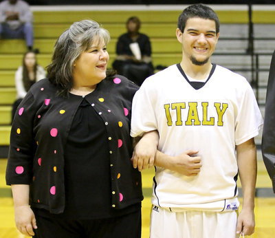 Image: Gladiator senior, Tyler Anderson(11) is escorted by his mother, Amy Anderson, during the pre-game ceremony.