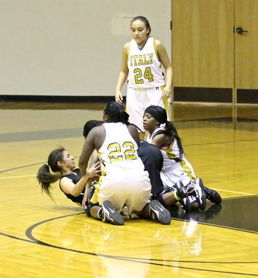 Image: Vanessa Cantu(24) observes as teammates Taleyia WIlson(22) and Kendra Copeland(10) hit the floor to tie up the ball.