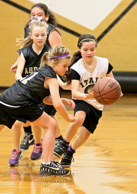 Image: IYAA’s Mikayla Venable(8) displays skill and will as she dribbles thru a trio of Abbott defenders during the 3rd/4th grade girls game.