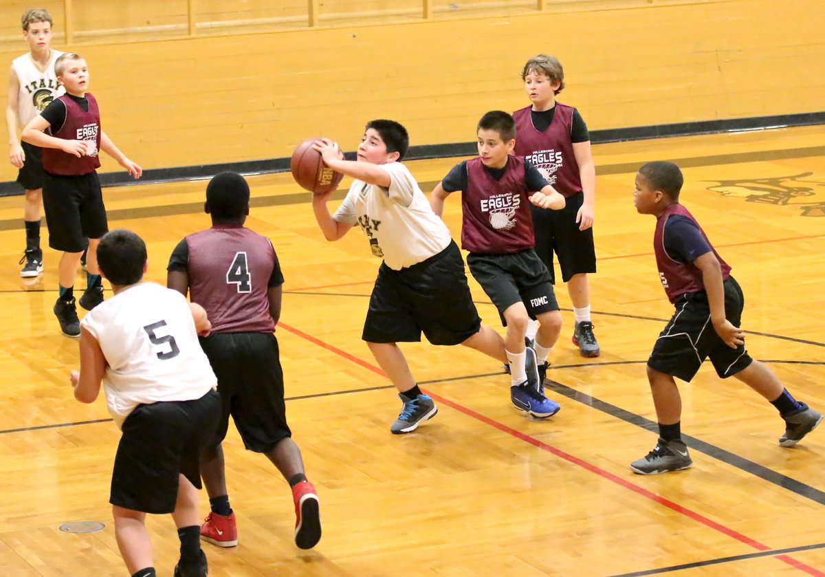 Image: IYAA’s Andrew Celis(1) takes a shot despite being entangled with a Hillsboro defender.