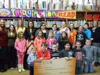 Image: Pam DuBose (high school librarian), top reading students and Denice Wimbish (elementary librarian) surrounding the big check!