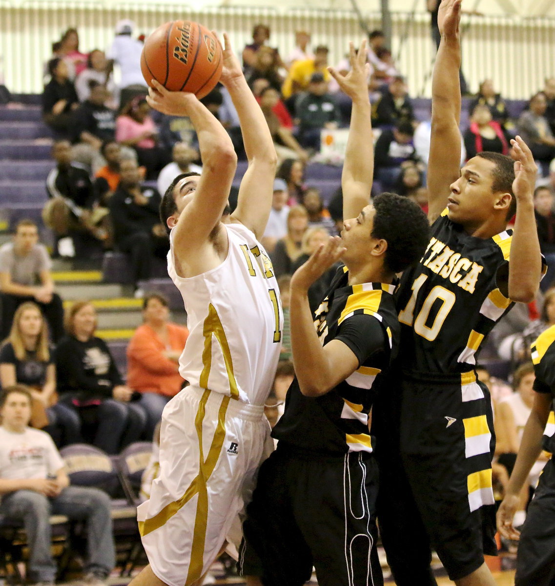 Image: Gladiator Tyler Anderson(11) drives the baseline to try a shot over a couple of Cat defenders.