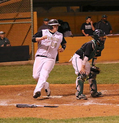 Image: John Byers(18) crosses home plate and then turns and waves his teammate down to slide in behind him.