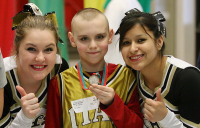 Image: Cheerleaders Taylor Turner and Jessica Garcia give Charlie Bolin(5) two thumbs up as he displays his 2nd place medal.