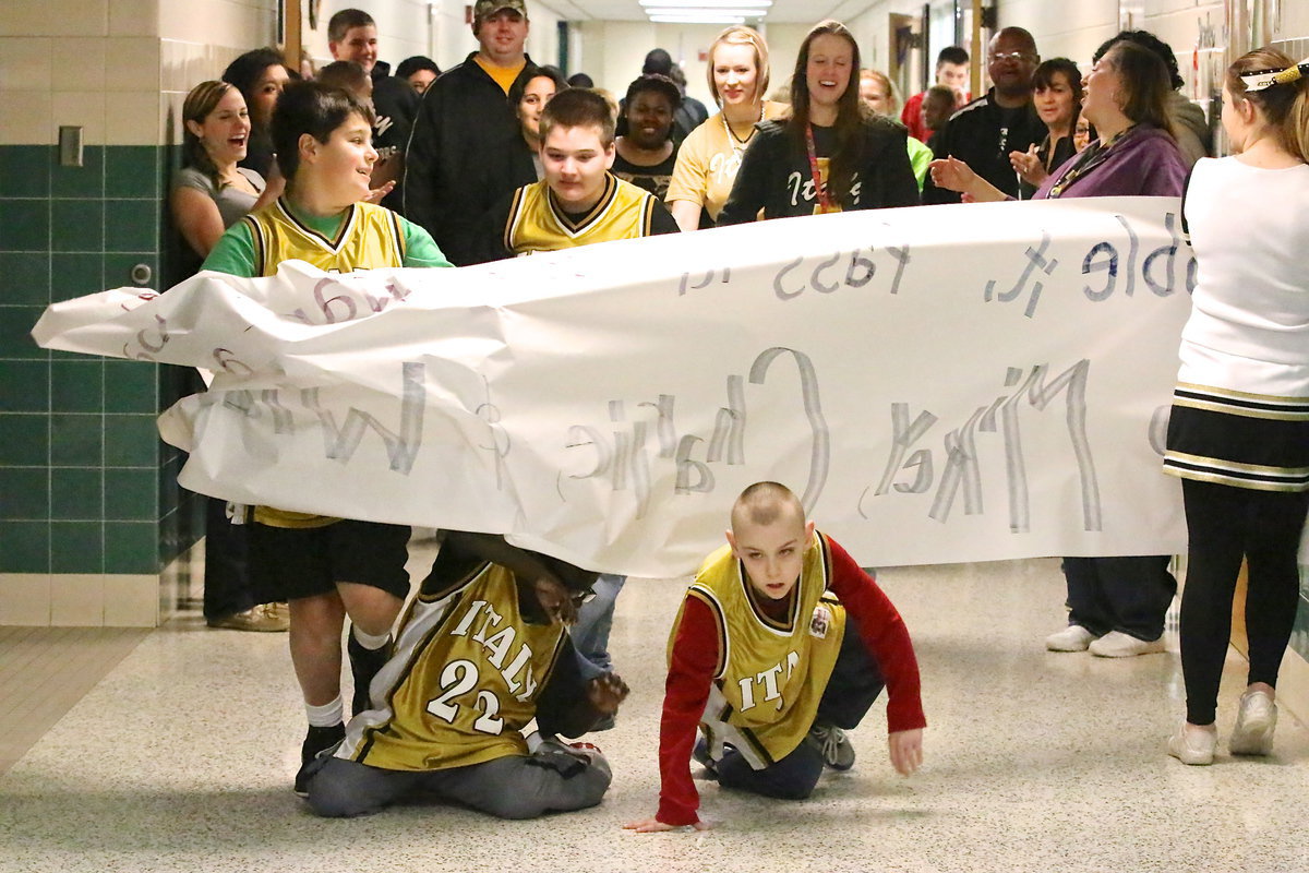 Image: One of the joys of being an athlete is the ceremonial busting thru the banner, or in some cases, sliding and crawling under.