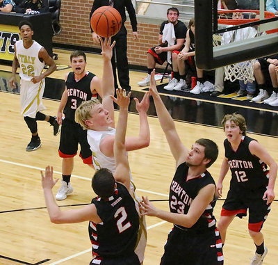 Image: Junior Gladiator Cody Boyd(15) scores at the front of the rim over two Tiger defenders.