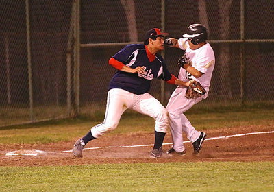 Image: After earning a walk, JV Gladiator Pedro Salazar(12) tries to fight his way onto the third base bag.