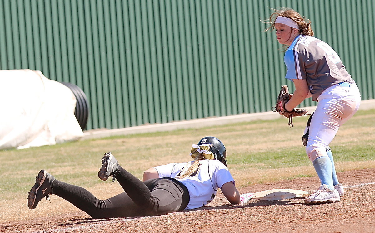 Image: Jaclynn Lewis(15) dives safely back to the third-base bag.