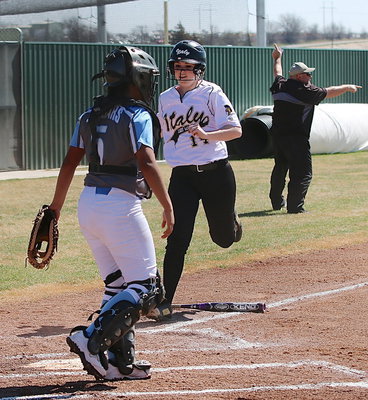 Image: Kelsey Nelson(14) crosses home plate for an Italy run as Lady Gladiator head coach Wayne Rowe directs his base runners.