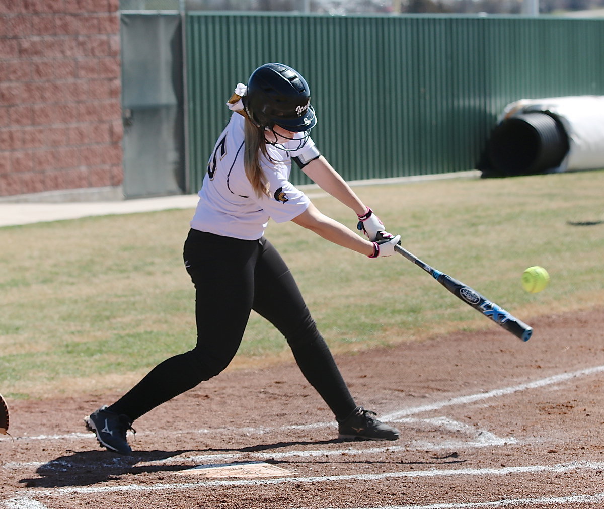 Image: Italy’s Jaclynn Lewis(15) drives a low pitch into the outfield for a single.