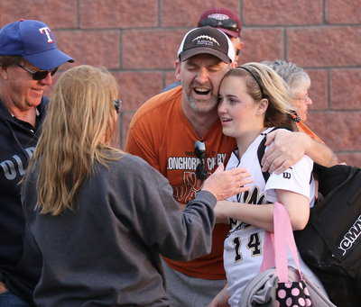 Image: Receiving post-game hugs from her grandparents, Harold and Paula Gray, and her very proud father, Doug Nelson, is Lady Gladiator Kelsey Nelson(14).