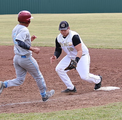 Image: First-base senior Kevin Roldan(16) secures the bobble in time to make the tag for an out.
