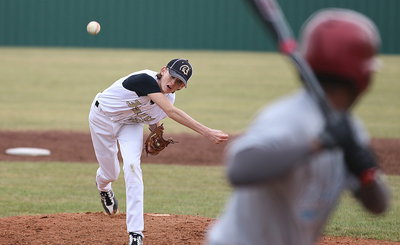 Image: Ty Windham(12) follows thru on a pitch against Roosevelt.