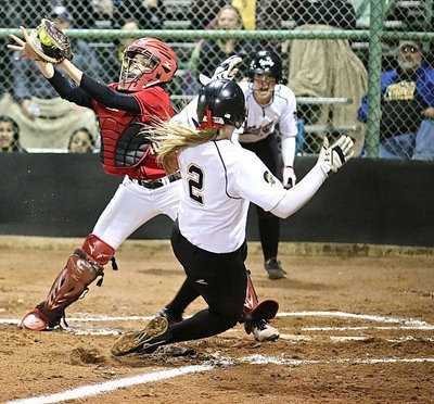 Image: Madison Washington(2) slides into home as teammate Jaclynn Lewis(15) yells for her to slide.