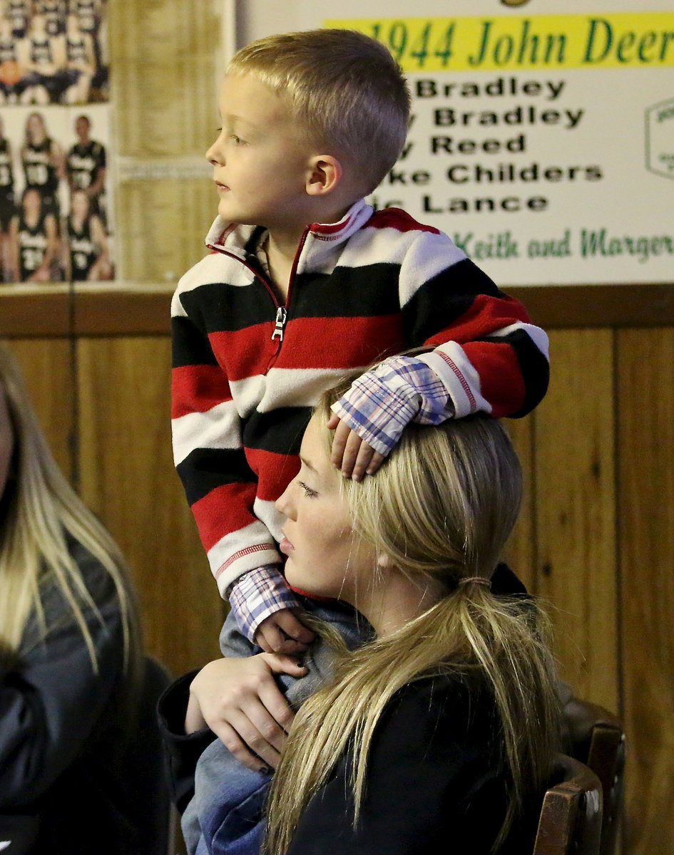 Image: Kace Campbell uses his aunt Hannah Washington to get a better view of the bidding war.