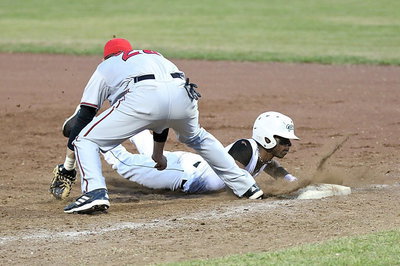 Image: Italy’s Eric Carson(2) makes it back to the first-base bag.