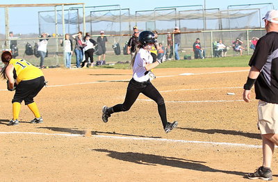 Image: A sprinting Britney Chambers(4) reaches first-base safely.
