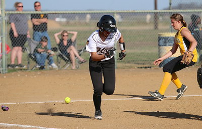 Image: April Lusk(18) bunts, runs fast and reaches first-base in time against Itasca.