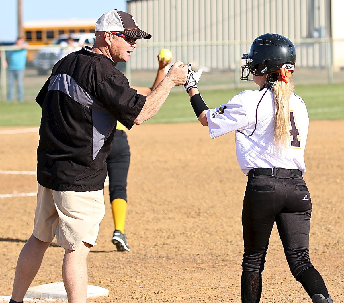 Image: First-base coach Michael Chambers congratulates his daughter Britney Chambers(4) after she slap hit her way onto the bag.