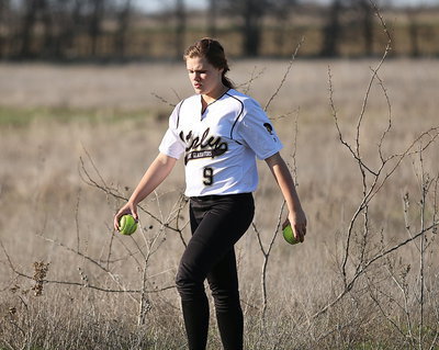 Image: Lillie Perry(9) gathers up some softballs from the middle of nowhere.
