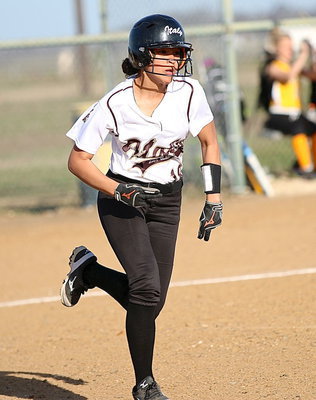 Image: April Lusk(18) hustles to first-base.