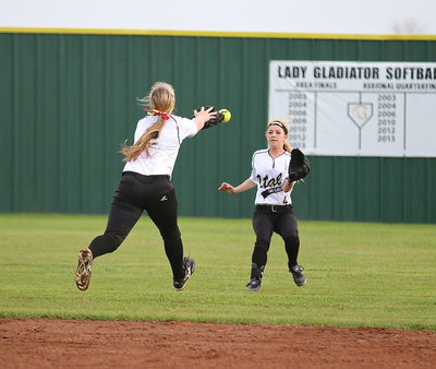 Image: Shortstop Madison Washington(2) tries to make an over-the-shoulder catch with left fielder Britney Chambers(4) backing her teammate up.
