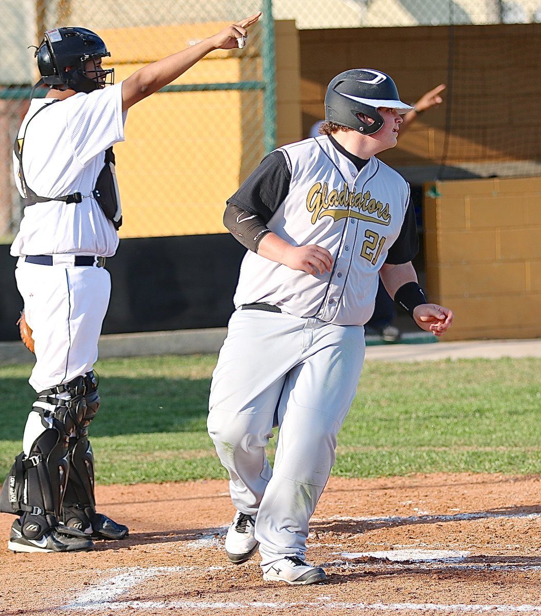 Image: John Byers(21) scores a run and then turns to signal Bailey Walton to come home.