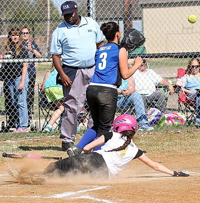 Image: Madison Galvan slides across the plate with Italy’s 14u Girls going for the win.