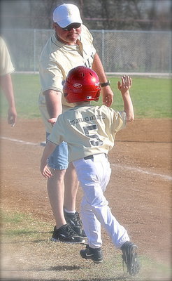 Image: Making memories — Coach Jackie Cate congratulates his son Austin Cate after Austin’s inside-the-park homerun helped seal the deal against Kopperl.