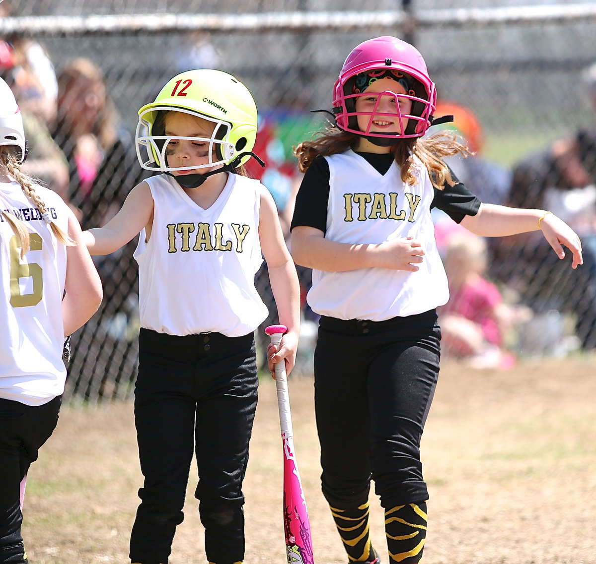 Image: Morgan Chambers gets set to bat after teammate Kinley Cate crosses home plate for a run.