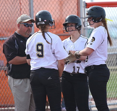 Image: Lady Gladiator head coach Wayne Rowe talks with Lillie Perry(9), Brooke DeBorde(17) and Madison Washington(2) during a pitching change by Avalon.