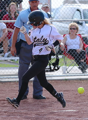 Image: Britney Chambers(4) is able to avoid the ball and cross home plate for an Italy run.