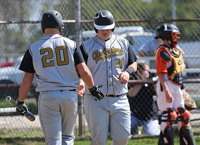 Image: Zain Byers(20) offers his cousin, John Byers(21), some love after “J.B.” scored a run.