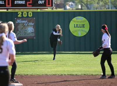 Image: Center fielder Kelsey Neslon(14) hurries the ball into the infield after covering a blooper.