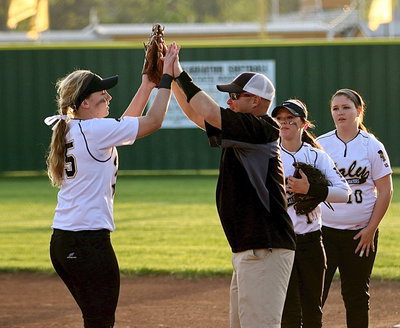 Image: Jaclynn Lewis(15) ends the game with her twelfth strikeout and then gets congratulated by assistant coach Michael Chambers and her teammates.