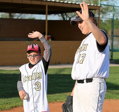 Image: IYAA baseball star Kinley Whatley(3) is named Gladiator Baseball’s honorary coach of the game as Italy celebrates White Out day against Itasca. Joining Whatley in waving to the home fans is senior Gladiator Bailey Walton(17).