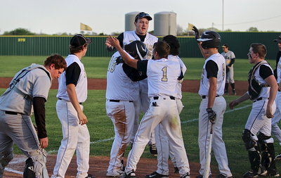 Image: John Byers(18) is congratulated by his teammates after finishing his homerun lap for the history books. Levi McBride(1) was the first official run up on the new scoreboard followed by Tyler Anderson(11).