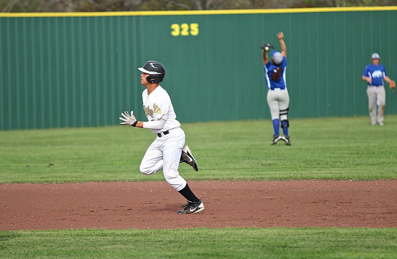 Image: Joe Celis(8) reaches third-base before Milford can complete their relay.