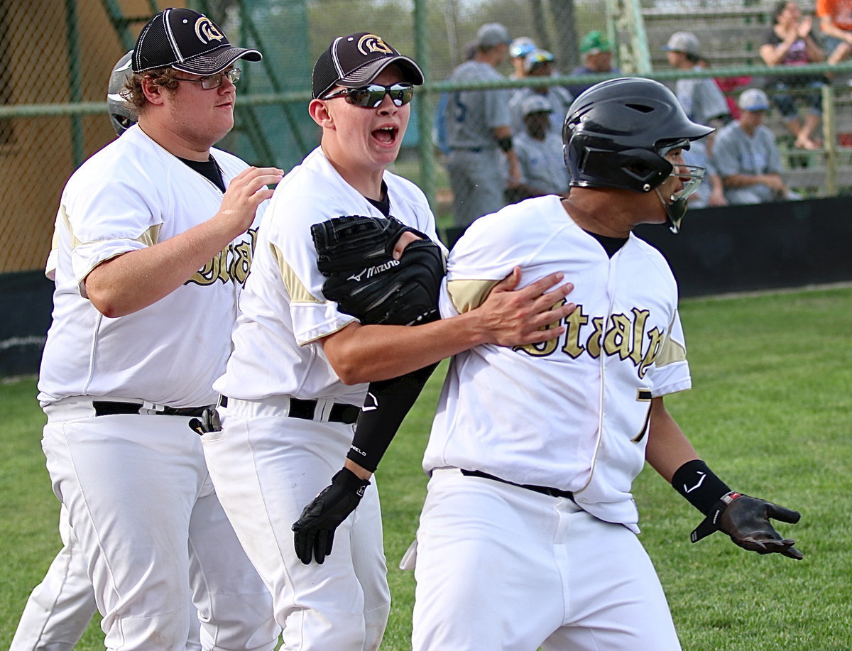 Image: Colin Newman and Austin Crawford congratulate teammate Tristan Cotten(7) after Cotten races home to give Italy’s JV a 7-6 lead.