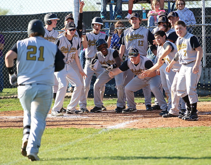 Image: Coming home! John Byers(21) trots in from third-base as his teammates await his arrival at home plate.