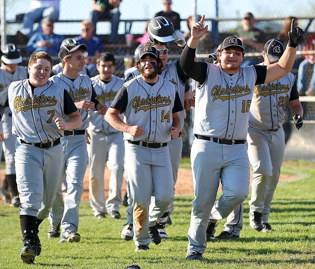 Image: John Escamilla(7), Kyle Fortenberry(14) and especially Kevin Roldan(16) enjoy the ensuing celebration after the homerun shot by John Byers(21), tipping his helmet, also went thru the uprights of the Frost goal post on the football field.